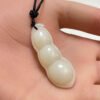 white jade carving of a three bean peapod pendant